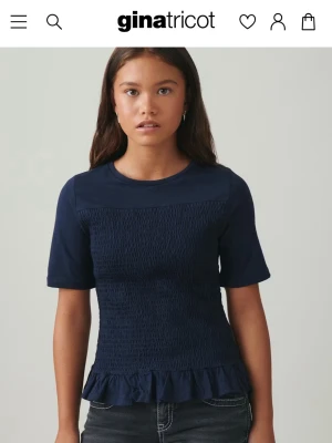 Marinblå smockad topp från - Säljer en marinblå topp från Gina Young i storlek 146/152,jätte fint skick bara använd få ggr.
