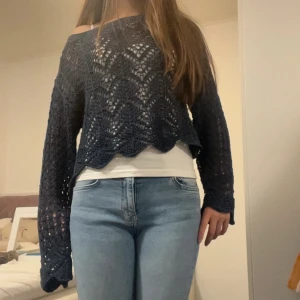 Mörkblå virkad stickad spets tröja från Zara - Snygg mörkblå virkad stickad tröja med off shoulder-modell och vågigt mönster. Tröjan har långa ärmar och en lös, croppad passform som ger en avslappnad vibe. Perfekt att styla över ett linne eller t-shirt.