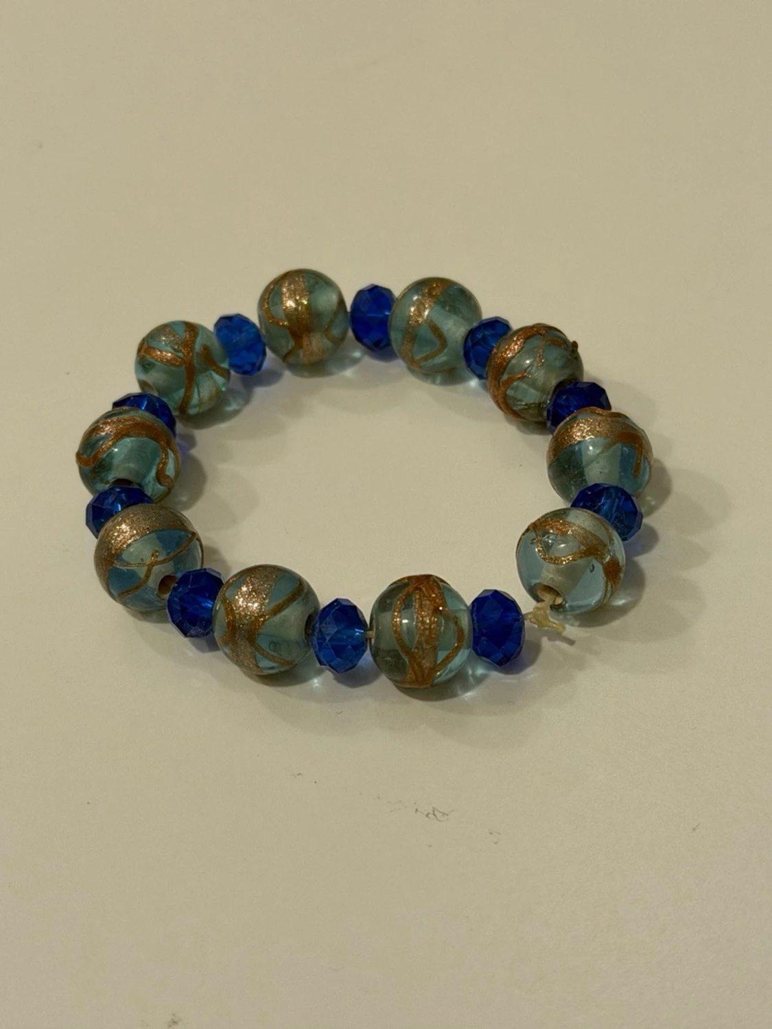 Blått pärlarmband med gulddetaljer