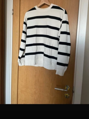 Vit och svart randig tröja XS - Vit långärmad tröja med svarta horisontella ränder. Klassisk rund halsringning och ribbade muddar vid ärmslut och nederkant. 
