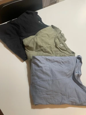 3-pack basic t-shirts från 157 - Tre basic t-shirts från 157 i svart, ljusgrön och ljusblå färg. Alla har klassisk rund halsringning och korta ärmar. Perfekta för en enkel och clean stil, lätta att matcha med allt. Tillverkade i mjuk bomull för skön känsla hela dagen.