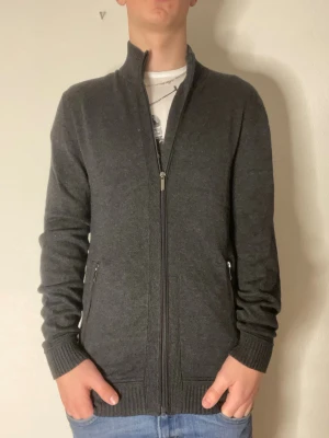 Snygg mörkgrå ziptröja - Tja jag säljer en snygg mörkgrå zip tröja med två fickor där fram. Modellen på bilderna är 178cm och väger cirka 70kg. Hör gärna av er vid funderingar // Mvh Partille closet
