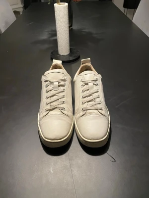 Christian Louboutin  - Säljer ett par stilrena vita sneakers i skinn med klassisk snörning och låg profil. Riktigt fräscha och passar perfekt till alla outfits. Skickar med dustbag med lite små saker i(tyvärr ingen box) Tveka inte att höra av dig ifall du har några frågor. Svarar så fort jag kan😊