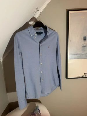 Ljusblå skjorta från Ralph Lauren - Klassisk ljusblå skjorta från Ralph Lauren. Skick 9/10. Inga slitage. Storlek M. Har du några frågor är det bara att skriva!
