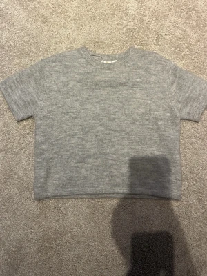 stickad grå kortärmad topp ifrån gina tricot - helt ny och aldrig använd med prislappen är borta, nypriset 199