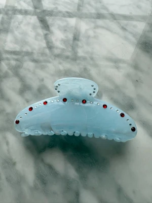 Ljusblå hårklämma med röda stenar - Hårklämma med glitter stenar från vårat uf företag Clip It UF