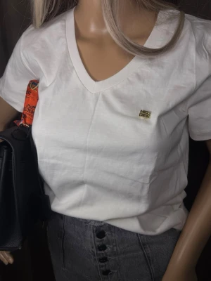 Vit t-shirt - Perfekt till jeans eller kjol för en clean och stilren look.