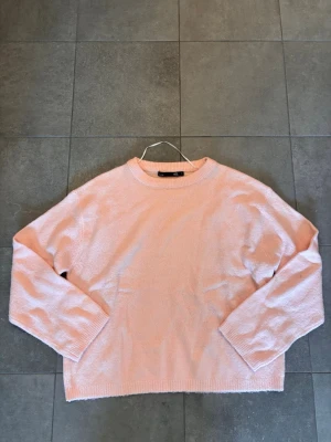 Ljusrosa stickad tröja  - Mysig ljusrosa stickad tröja från 157 med rund halsringning och ribbade muddar vid ärmslut och nederkant. Tröjan har en avslappnad passform och är perfekt för lager på lager. Materialet känns mjukt och behagligt mot huden.