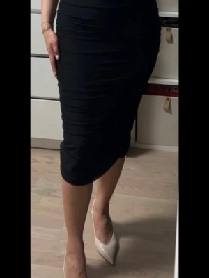 Svart tight långklänning - Säljer en svart, tight långklänning med figurnära passform. Klänningen har en enkel och stilren design utan synliga detaljer eller mönster. Perfekt för dig som gillar en klassisk och elegant look.