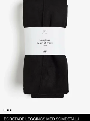 Svarta leggings med sömdetalj H&M - XS-S Borstat svarta leggings från H&M med sömdetalj framtill. De har en tight passform och är tillverkade i mjukt syntetmaterial som känns skönt mot huden. Perfekta för en clean och stilren look.