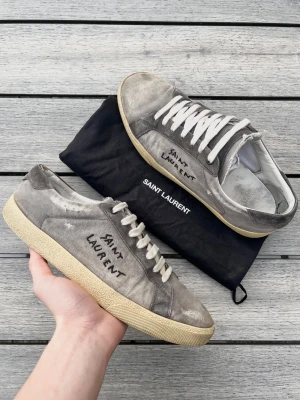 Grå Saint Laurent skor  - Ysl skor i en väldigt sällsynt och fet modell! Bra skick, inga tydliga defekter men de är använda. Dustbag medföljer. Storlek 43. Kontakta mig för fler frågor och funderingar!