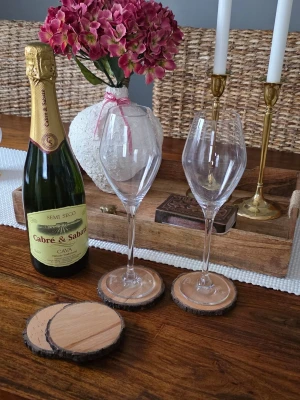 Rustika glasunderlägg i trä - Säljer fyra runda glasunderlägg i ljust trä med naturlig barkkant. Perfekta för att ge en mysig och naturnära känsla till dukningen. Passar både till glas och muggar och blir en snygg detalj på bordet.