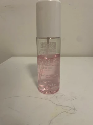 Sugar Berry Body Mist - Fräsch body mist från Caramella i doften Sugar Berry. Flaskan är genomskinlig med rosa vätska och har ett vitt lock. Perfekt för dig som gillar söta och bäriga dofter. Smidig plastflaska på 3.4 fl oz som är lätt att ta med i väskan.