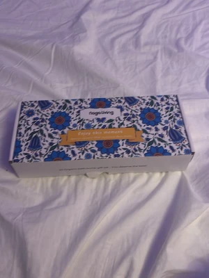 Naga Living presentbox med badbomber - Presentbox från Naga Living med tio färgglada badbomber i olika dofter. Badbomberna är runda och kommer i en dekorativ låda med blommigt mönster i blått, vitt och orange. Perfekt för dig som vill lyxa till badstunden med härliga dofter och färger.