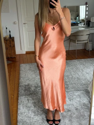 Klänning - Design by Si - Säljer min helt oanvända aprikosa mediumlånga klänning. Helt oanvänd. Klänningen är klippt i kanten för att för att få en jämnare längd. Storlek XS/S. Superfin till sommaren❤️