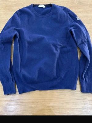 Moncler klassisk blå tröja – äkta, fint skick - Säljer en äkta Moncler tröja i blå färg med klassisk patch på armen.  🧵 Skick: Mycket bra / gott skick (se bilder) 📏 Storlek: L fast passar Xs och xxs  🧼 Inget hål, inga fläckar  Perfekt plagg till både vardag och finare outfits. Skriv gärna om du vill ha fler detaljbilder!