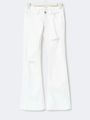 Vita bootcut jeans med slitningar - Säljer ett par vita bootcut jeans med lätt slitna detaljer på låret och knät. Jeansen har klassisk femficksmodell, låg midja och vida ben. Perfekta för dig som vill ha en clean look