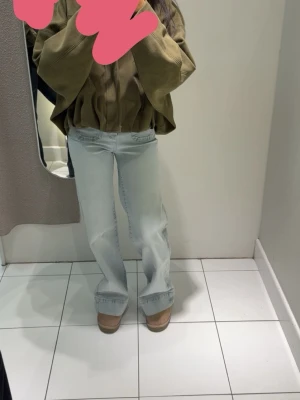 Ljusblå raka jeans med hög midja - Säljer ett par ljusblå jeans med rak passform och hög midja med knappar och fickor framtill. 