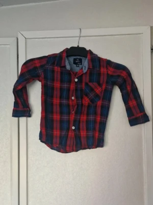 Röd och blårutig skjorta - Långärmad skjorta. Inga funna skavanker. Stl 98