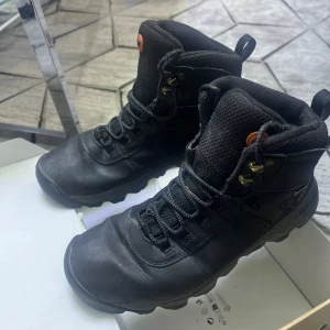 Svarta kängor från Merrell - Ett par svarta kängor från Merrell med högt skaft, robust sula och snörning. Tillverkade i slitstarkt material och passar perfekt för utomhusaktiviteter. Nypris 1400:- Vår pris 400:- (Ifall det önskas polering och rengöring 50:- tilläggspris kunden bestämmer det själv.) 