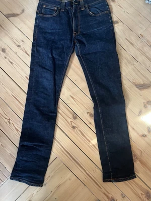 Mörkblå jeans från Nudie Jeans - Nudie jeans Tape ted! Säljes för att det är för små.😃 strl 34/34                                                                              Mått: 38 midja, 106 längd, 17 benöppning 