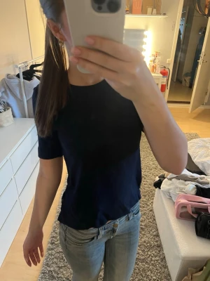 Mörkblå ribbad t-shirt - Säljer en mörkblå ribbad t-shirt med korta ärmar och rund hals. Storlek XS från bondelid. T-shirten har en enkel och stilren design som passar till det mesta. Perfekt till jeans eller kjol för en avslappnad look. Skriv om du undrar något💕