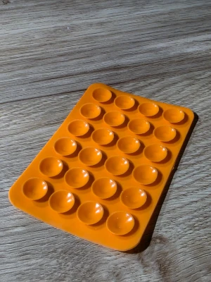 Orange mobilskal med pop-it design - Säljer ett orange mobilskal med pop-it design som ger en rolig och unik känsla till din mobil. Skalet är gjort av mjukt silikonmaterial och har en rektangulär form med rundade hörn. Perfekt för dig som vill ha något annorlunda och lekfullt till mobilen.