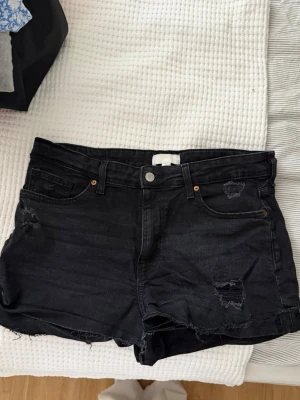 Slitna svarta shorts - Säljer ett par svarta slitna shorts från H&M! Storlek 44! Använts ett par gånger men ingenting jag anser syns. Hör av dig vid frågor!🥰