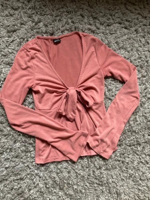 Rosa knyttopp  - Supersnygg rosa omlottopp från Gina Tricot med lång ärm och knyt framtill. Inga defekter, skriv om du undrar något!