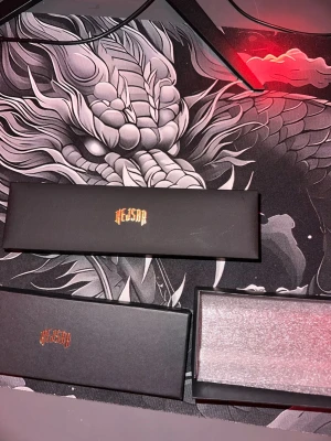 Rött KEJSAR armband med klöver - Säljer ett snyggt armband från KEJSAR med röda klöverformade detaljer och silverfärgad kedja. Armbandet levereras i original ask och har en modern, stilren design som passar perfekt till din outfit.