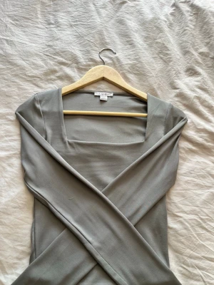 Grå långärmad topp från new yorker - Snygg grå långärmad topp från new yorker med fyrkantig ringning.