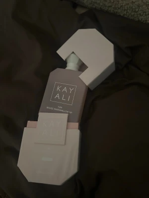 100ml Kayali Yum Boujee Marshmallow - Kayali Yum Boujee Marshmallow 61 är en parfym i en matt ljusrosa flaska med vit geometrisk kork. Flaskan har en modern, stilren design och kommer i en matchande rosa förpackning. Doften är söt och lekfull, inspirerad av marshmallows och passar dig som gillar gourmanddofter.