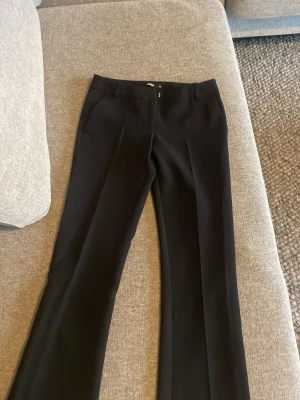 Vera tall flared kostymbyxa  - Säljer mina svarta low waist kostymbyxor från bikbok i storleken 34 tall. Dem har aldrig används då byxorna är för små i midjan på mig, nypris 499🌸