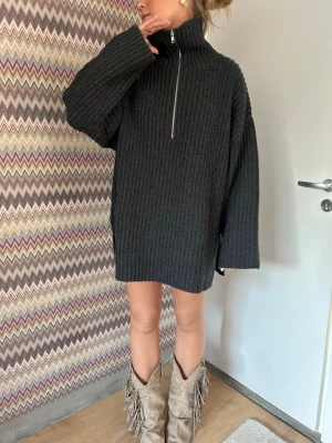 Stockad soft goat tröja! - Soft goat tröja som går att ha på många olika sätt! ALDRIG ANVÄND LAPPEN KVAR! Säljer en mörkgrå oversized stickad tröja med hög krage och halv dragkedja framtill. Tröjan har grov ribbstickning, långa ärmar och en avslappnad passform. Perfekt för lager på lager och en cool, avslappnad stil.