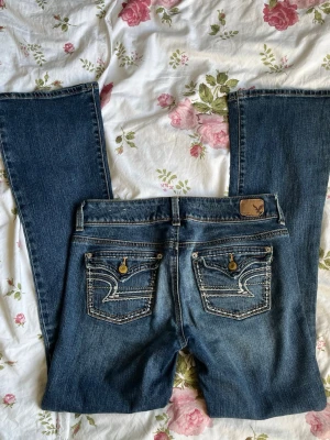 American eagle jeans - Lågmidjade bootcut jeans från AE❤️ lite slitna längst ner som man kan se på bilden. Midjemått 38cm innerbenslängd 79cm