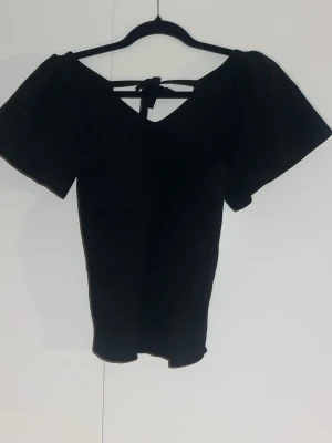 Svart topp - Svart topp med v-ringning och knytband