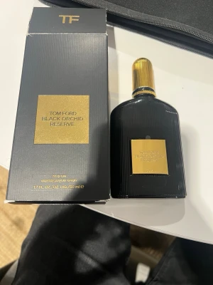 Tom Ford Black Orchid Reserve parfym - Tom Ford Black Orchid Reserve är en exklusiv parfym i en elegant svart flaska med gulddetaljer och räfflad yta. Flaskan har en lyxig känsla med guldfärgad etikett och lock. Kommer i originalförpackning med matchande svart och guld design. 99% kvar 