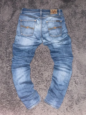 Nudie | Grim Tim  - Snygga Nudie jeans i färgen ljusblå! ⭐️ Det är storlek 31W 34L. Modellen heter Grim Tim! ⚜️ Riktigt feta! 🔥