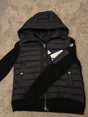 Svart Moncler Cardigan - En helt ny Moncler Cardigan som jag råkat köpa fel nummer av. Den är 100% skadefri har aldrig gått ut eller bärt runt på den. Top kvalitet, varje detalj sitter och den är väldigt skön. Man kan bära den på våren för den är inte så tjock (ha en tjock tröja under för o va säker hälst om det är kallt ) Storlek S men M och XS kan bära den utan problem. OBS! Pris kan diskuteras!
