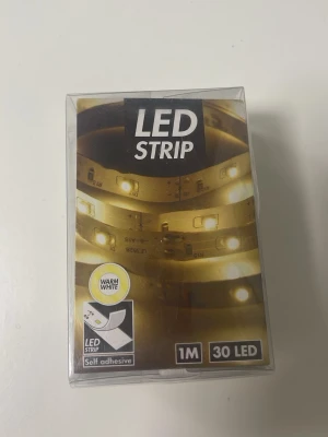 LED strip 1 meter varmvit - Självhäftande LED strip på 1 meter med 30 varmvita LED-lampor. Perfekt för att lysa upp skrivbord, hyllor eller andra ytor. Drivs med 3x AA-batterier (ingår ej). ❗️Skriv hur många paket du vill ha innan du köper❗️ (13kr/st