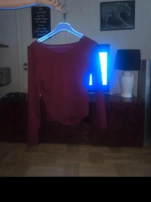 Vinröd långärmad topp - En enkel och stilren vinröd långärmad topp med rund halsringning. Perfekt att matcha med jeans eller kjol för en clean look. Mjuk och skön, passar till många olika outfits.