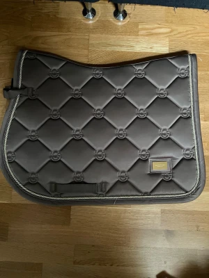 Champagne färgat schabrak ifrån Es säljes! - Säljer ett snyggt schabrak ifrån Equestrian Stockholm i storlek FULL! Schabraket är Beige (kallas Champagne) med läckra gulddetaljer! Schabrak har ALDRIG använts och är helt nytt utan prislapp! Nypriset är 899kr men jag säljer för 699kr💕💕