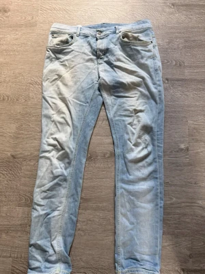 Ljusblå dondup Jeans med vita detaljer - Säljer ett par ljusblå jeans från dondup med vita ditaljer
