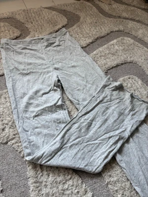 Ljusgrå mjukisbyxor från H&M - Ljusgrå mjukisbyxor från H&M i mjukt och stretchigt bomullsmaterial. Byxorna har en enkel, rak passform och resår i midjan för extra komfort. Perfekta för chill dagar hemma eller när du vill ha det riktigt bekvämt.