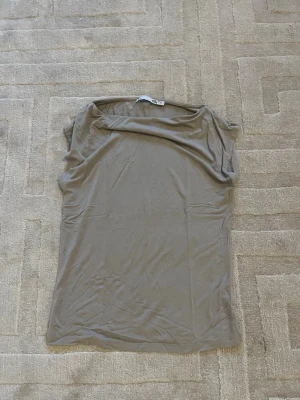 Beige ärmlös topp från 157 - Säljer en enkel och stilren beige ärmlös topp från 157. Toppen har en rak passform och är tillverkad i ett mjukt material som känns skönt mot huden. Perfekt att matcha med jeans eller kjol för en clean look.