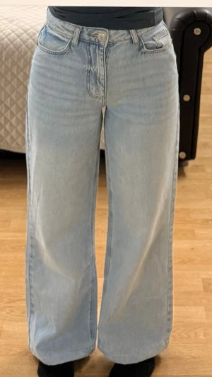Ljusblå wide leg jeans från amisu  - Säljer ett par ljusblå wide leg jeans från amisu. Jeansen har hög midja, raka och vida ben samt klassiska fem fickor. Tillverkade i bomull för en skön och avslappnad look. Perfekta till sneakers eller boots.