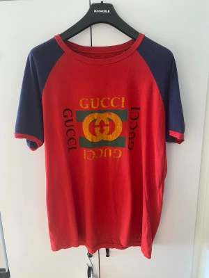 Gucci t shirt - Säljer denna snygga t shirt från gucci. Modellen är att den ska vara distressed (se använd ut). Storlek L passar även XL. Ingen neck tag och tvättlappen har tappar sitt tryck.   Mått: Längd 74 cm, bredd (under armhålorna) 56cm
