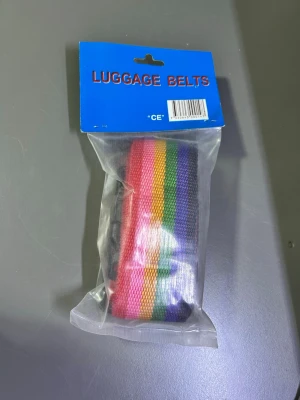 Randigt regnbågsfärgat bälte - Färgglatt bälte med breda ränder i regnbågens färger. Perfekt accessoar för dig som vill sticka ut och addera lite färg till din outfit. Tillverkat i slitstarkt syntetmaterial och har en klassisk form. Finns fler kvar 