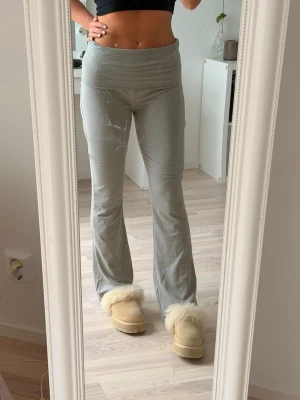 Grå bootcut mjukisbyxor - Säljer ett par grå mjukisbyxor med bootcut-modell och hög midja. Byxorna är i mjukt och stretchigt material, perfekta för chill dagar hemma eller när du vill vara bekväm men ändå se snygg ut. Inga fickor och enkel design.