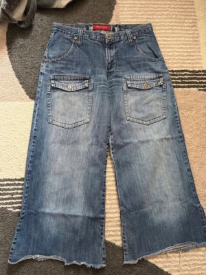 Wide jeans - Säljer ett par blåa jeans från Replay med breda ben och råa, fransiga kanter. Midja 40cm Innerben 68cm
